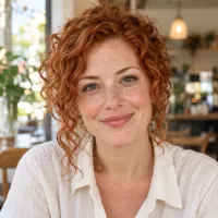 Portrait of a woman with curly red hair in a café.