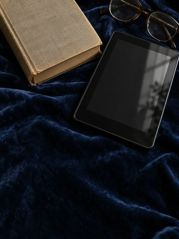 The cover of "Your ebook isn’t selling? The guide": a switched-off e-reader, an old book and glasses on navy velvet.